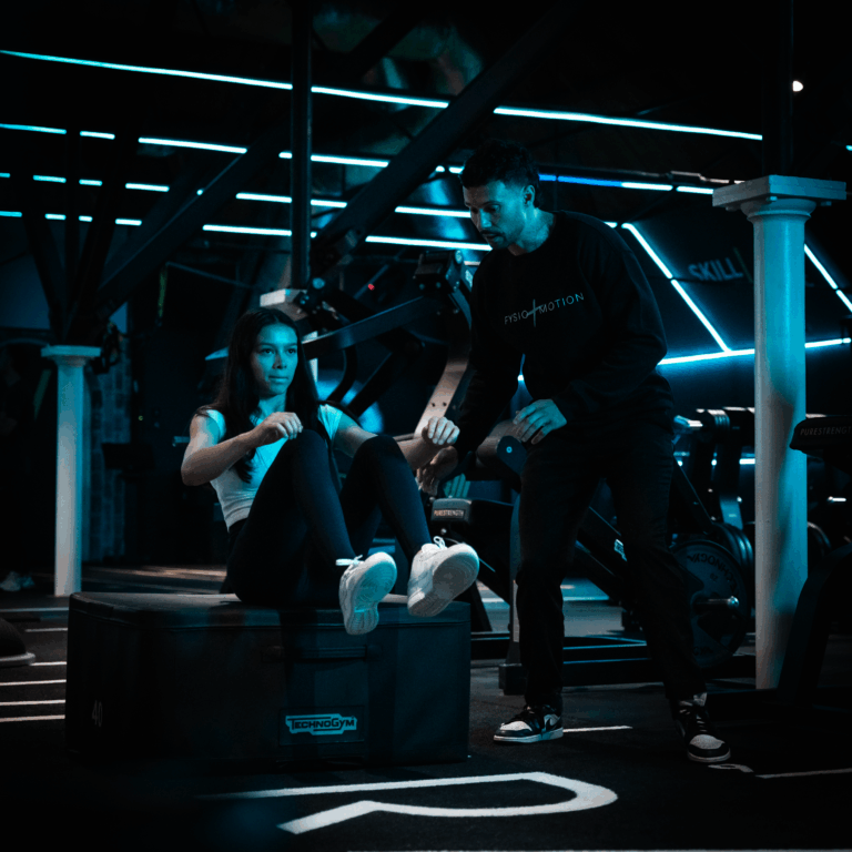 A man and woman sitting on a box in a gym. Fysiotherapie. Fysio & Motion – Voor Herstel, Prestatie En Beweging Sport ffysio