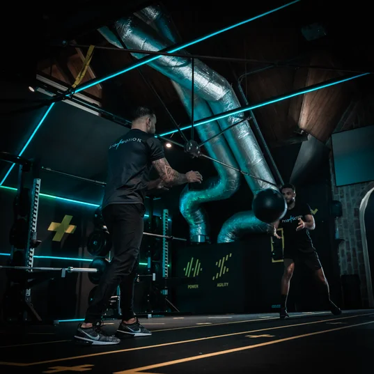 Explosieve reactietraining met een medicijnbal op de sprintbaan voor geavanceerde sportrevalidatie.