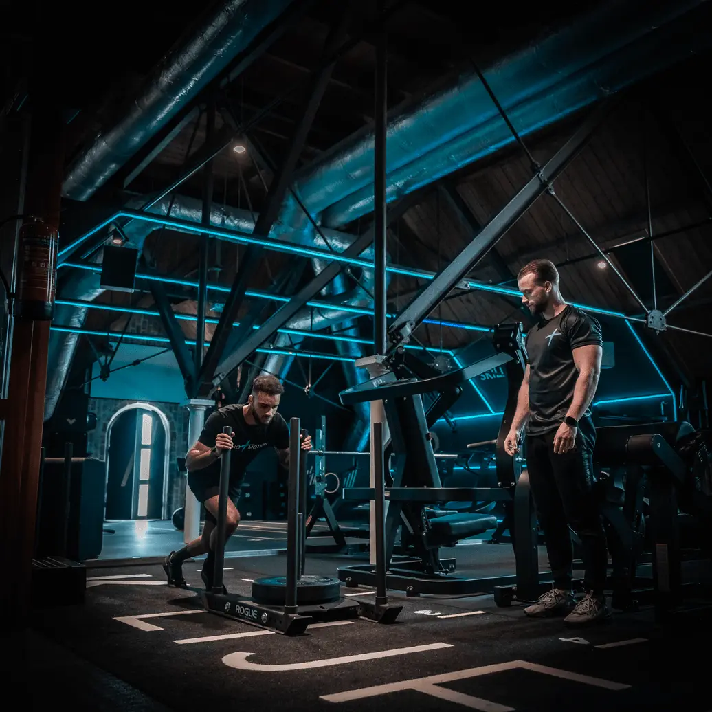 Fysiotherapeut van Fysio & Motion begeleidt patiënt bij slee-training in Assendelft