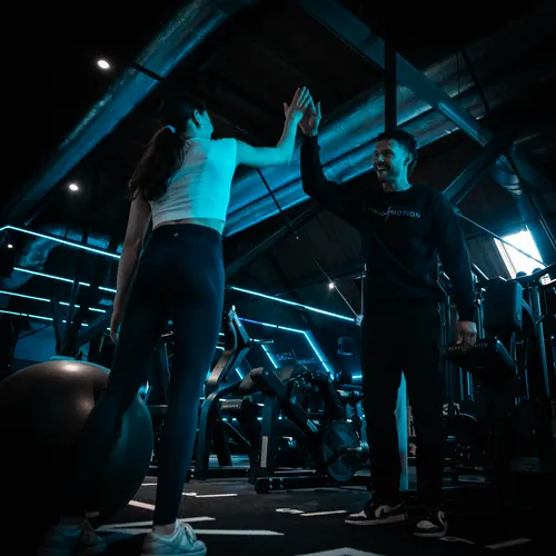 Fysiotherapeut geeft high five aan patiënt na sportfysiotherapie behandeling bij Fysio & Motion Wormer