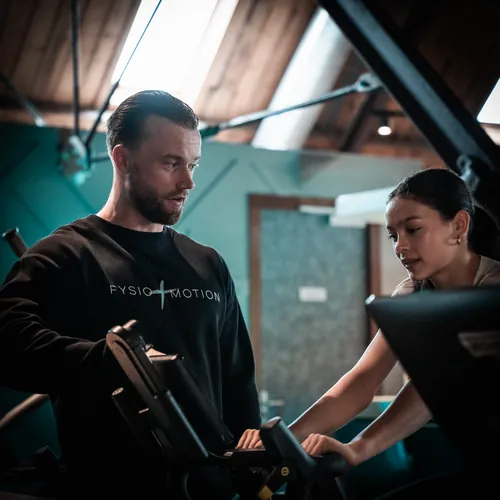 Mick begeleidt patiënte bij personal training op Technogym apparatuur